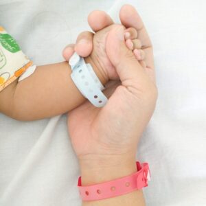 Holding hands with hospital wristbands.